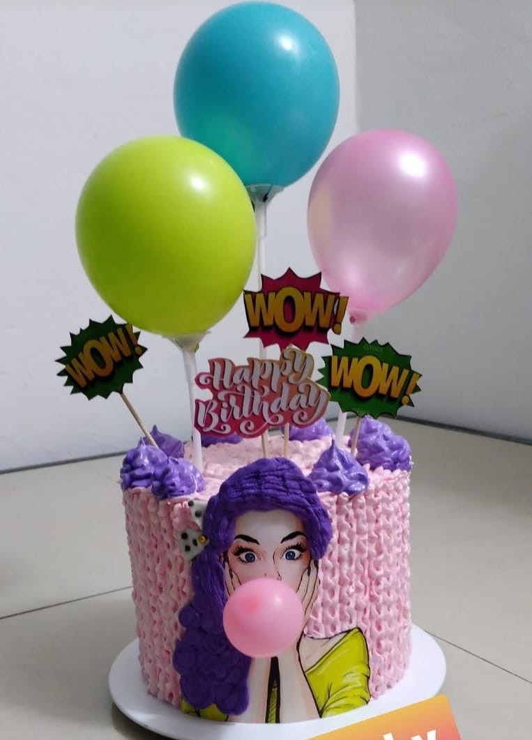 Pastel rosa con decoración de cumpleaños y globos
